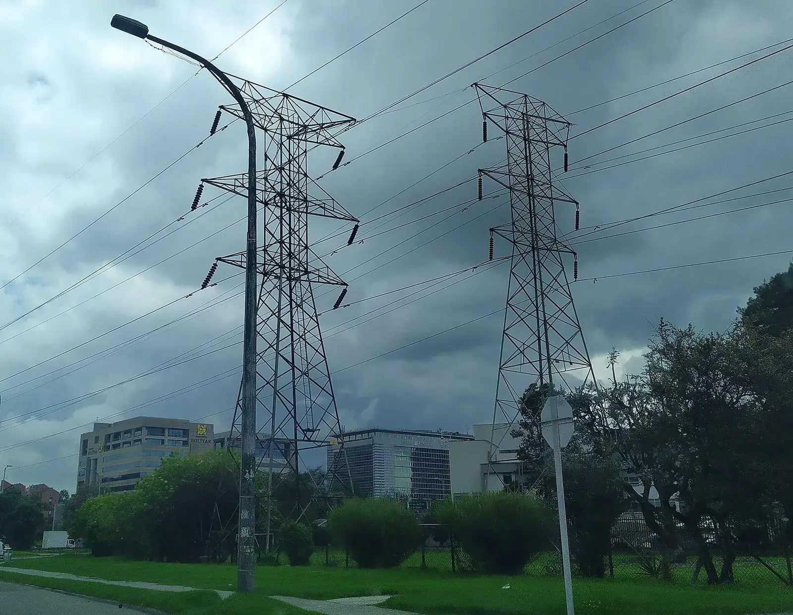 Dos torres eléctricas de celosía con líneas de alta tensión en una zona urbana de Bogotá, Colombia
