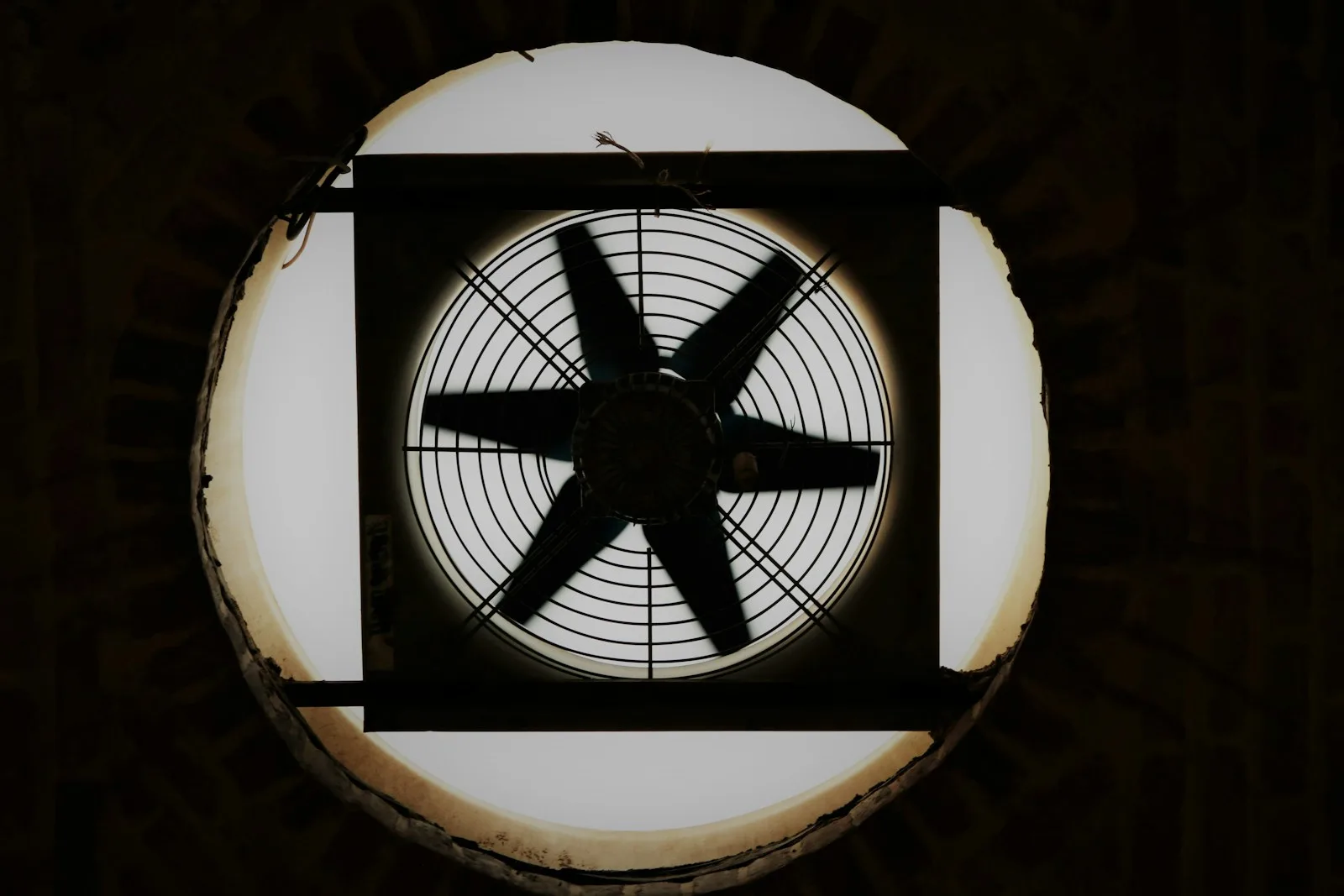 Extractor de aire montado en una ventana circular, a contraluz