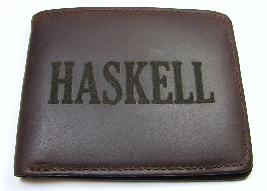 Cartera de piel marrón con un nombre grabado a láser en un tono más oscuro que el resto del cuero