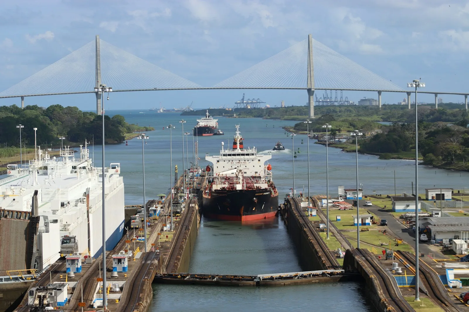 Buque de carga dentro de las esclusas de Gatún del Canal de Panamá, con el puente del Atlántico al fondo