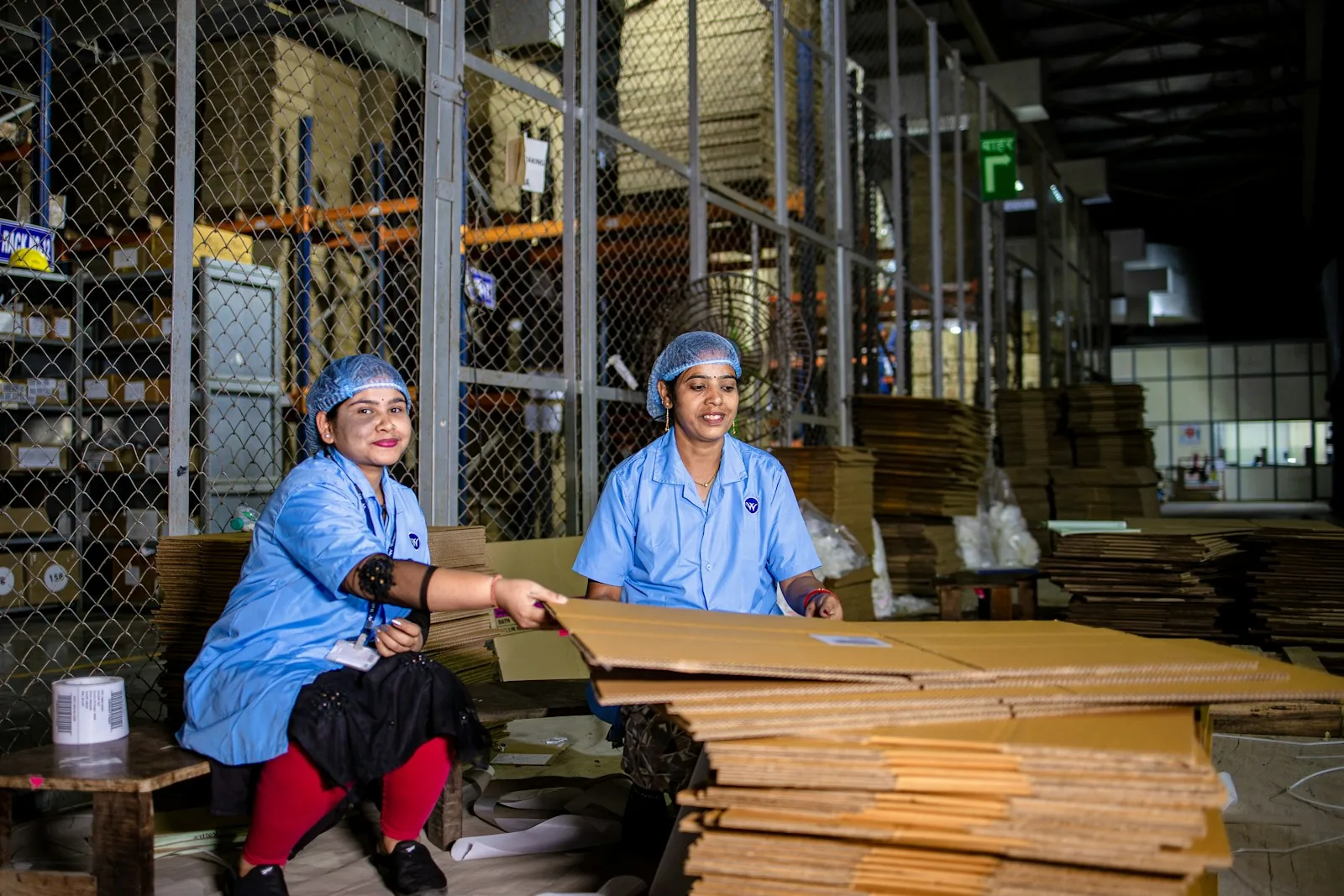 Trabajadoras preparando cajas de cartón en un almacén logístico