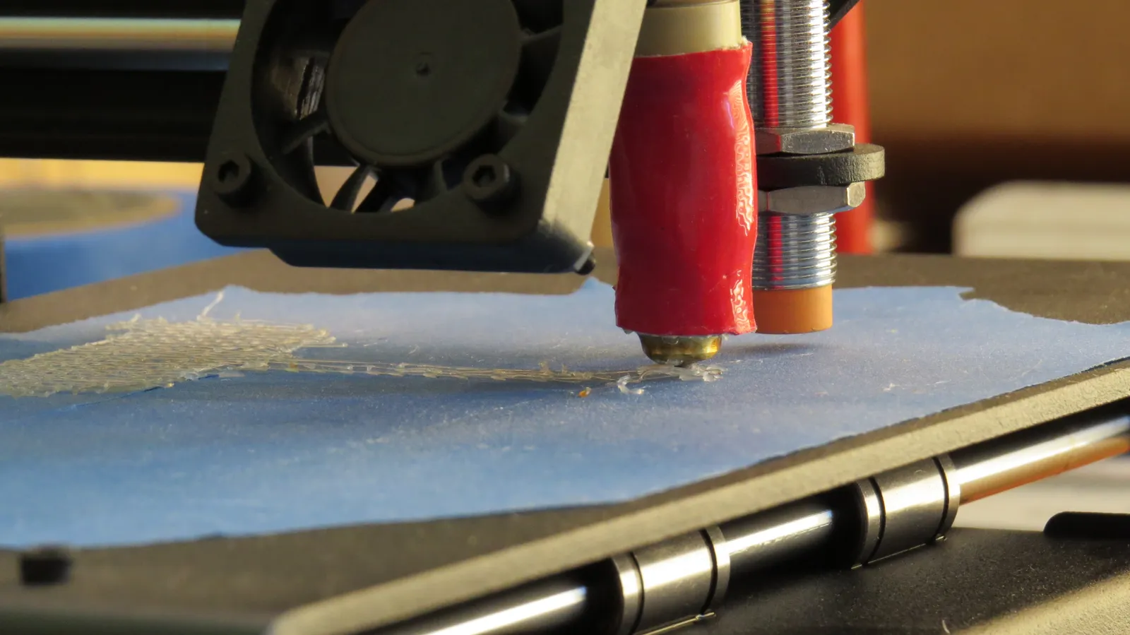 Boquilla de una impresora 3D depositando la primera capa sobre la cama