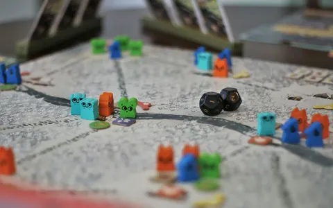 Fichas y dados impresos en 3D en varios colores sobre un tablero de juego